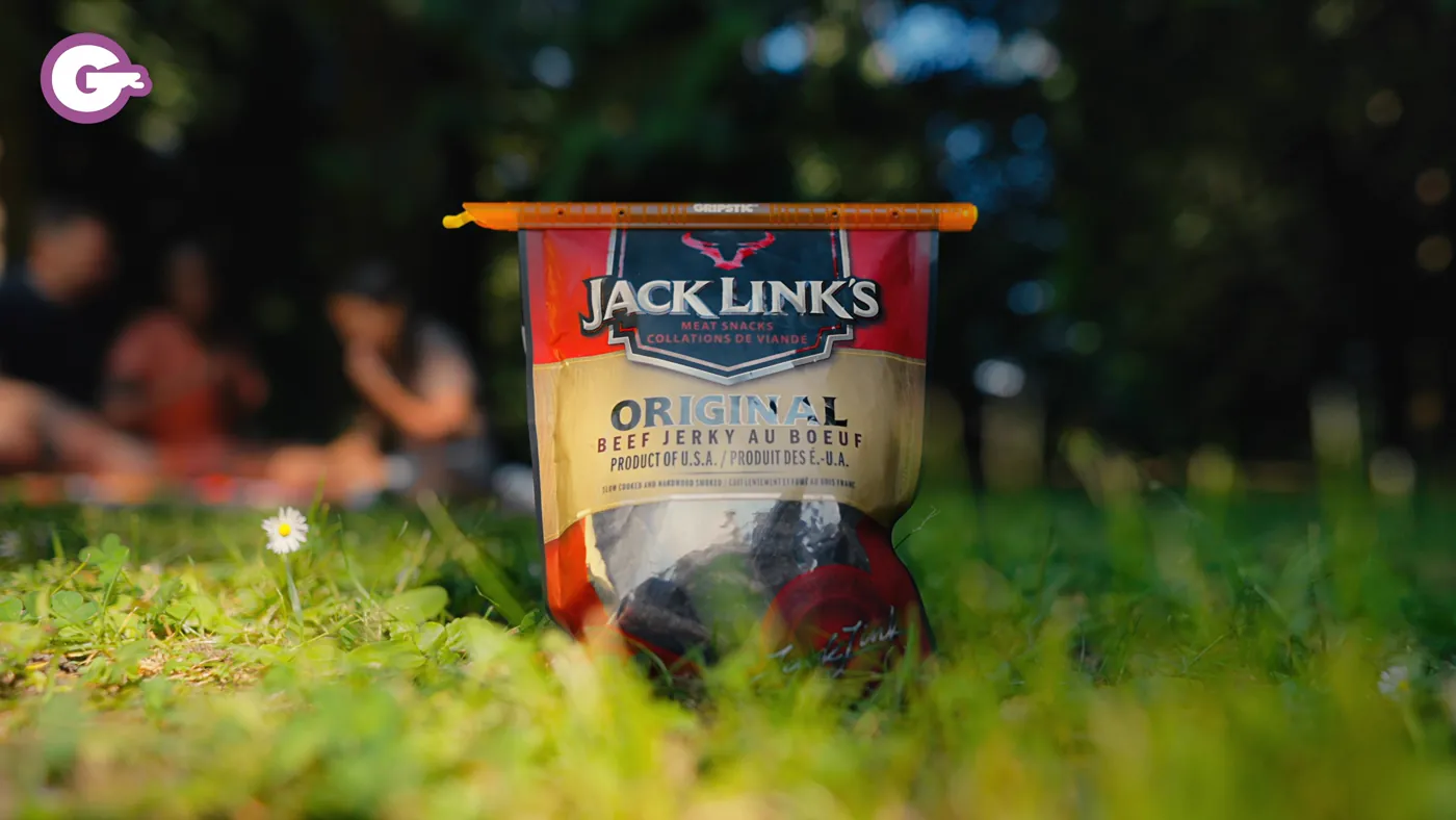 A sealed bag of jerky on the grass at a picnic