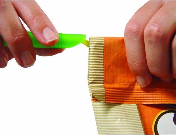 Hands folding the top of a chip bag and lining up a green GRIPSTIC