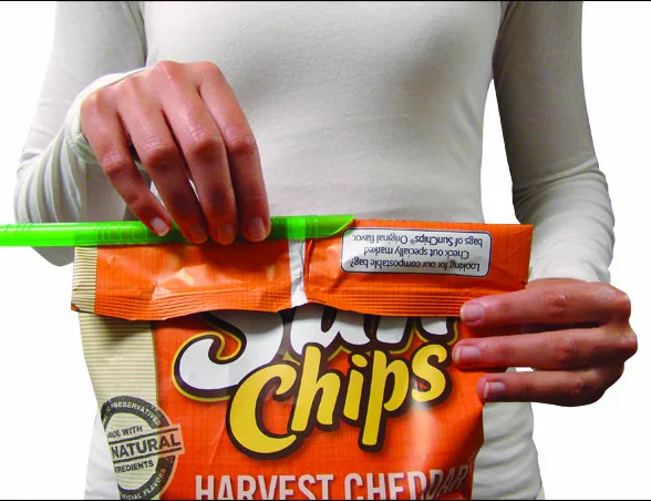 A GRIPSTIC sliding across the folded top of a chip bag